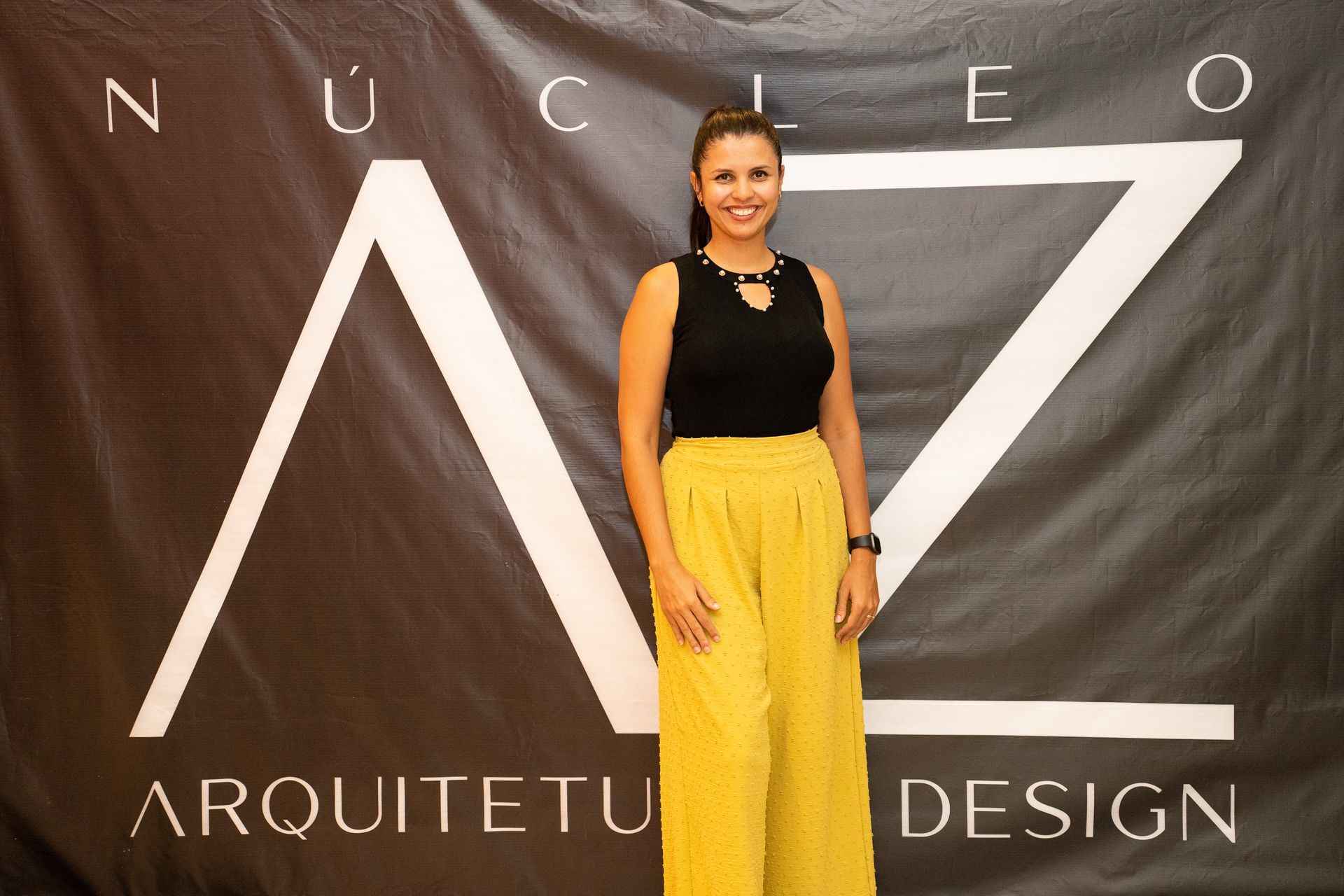 Uma mulher está em frente a uma placa que diz arquitetu design