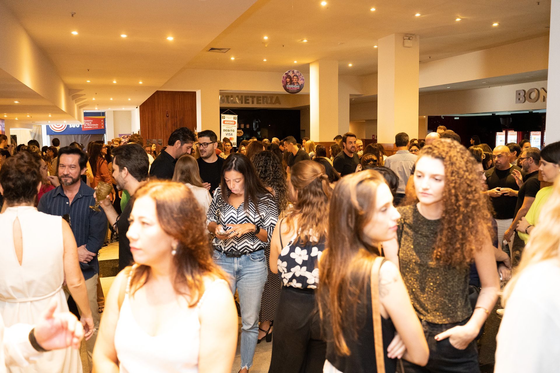 Um grande grupo de pessoas está em pé em uma sala.