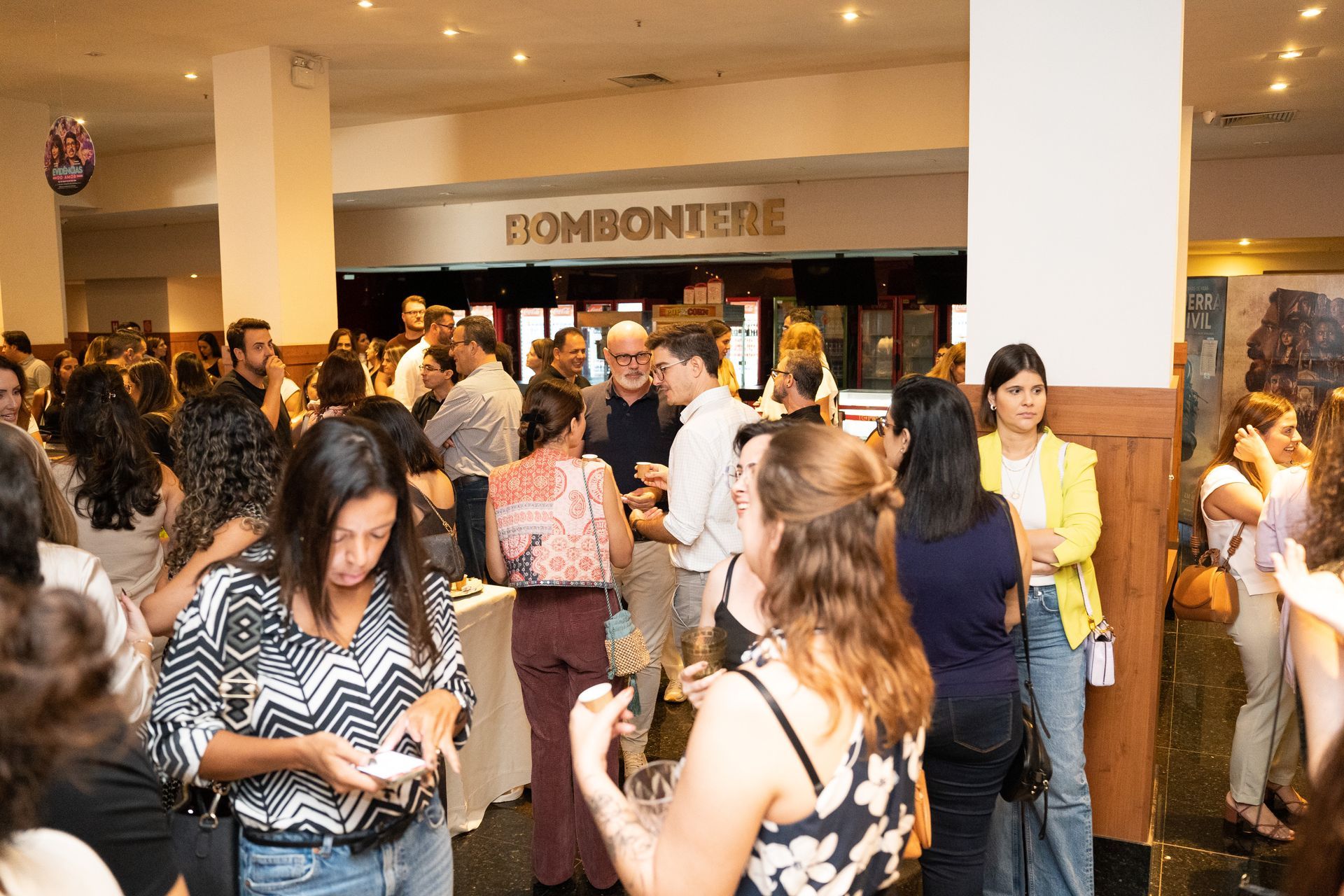 Um grande grupo de pessoas está em pé em uma sala.