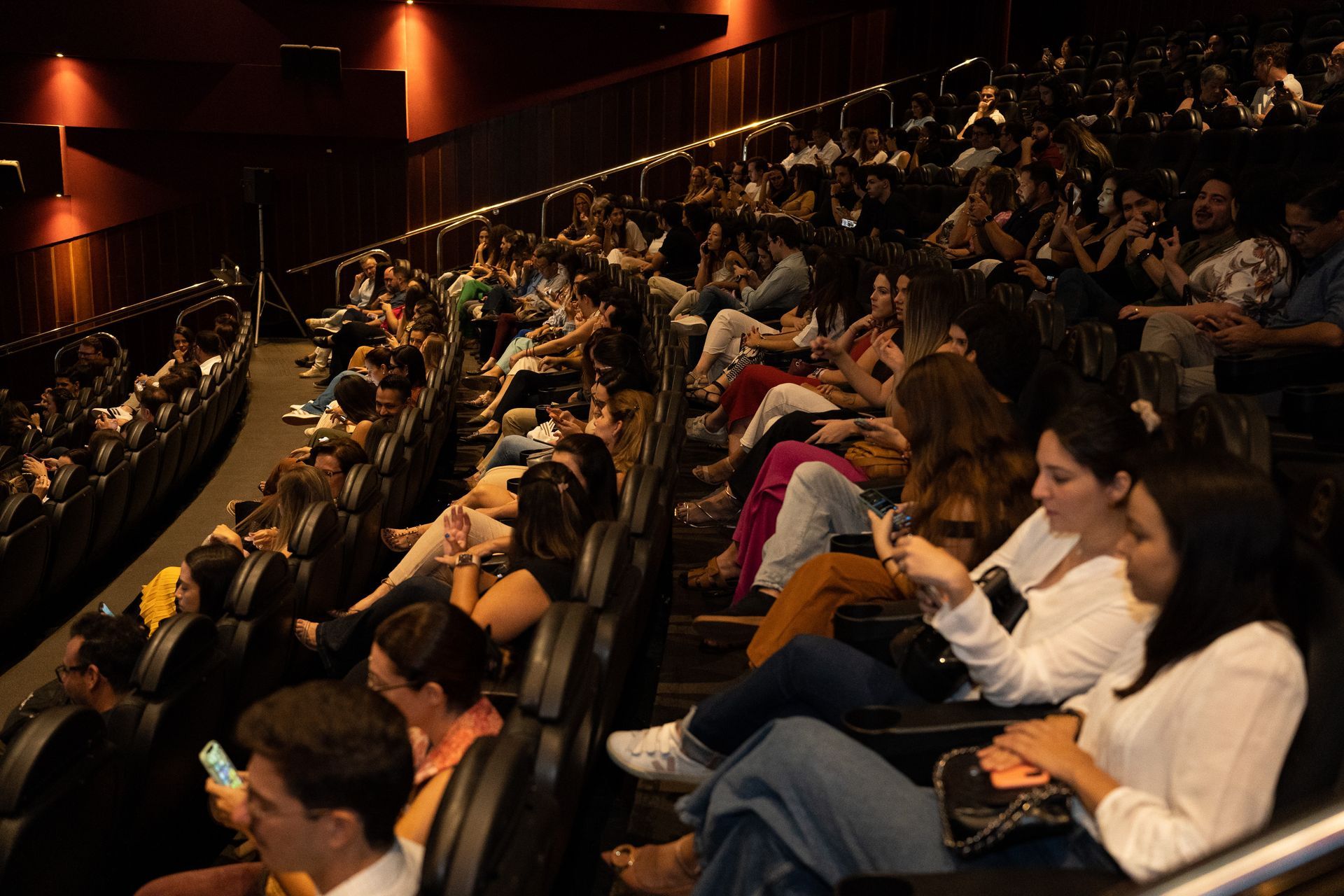 Uma multidão de pessoas está sentada em um teatro assistindo a um show.