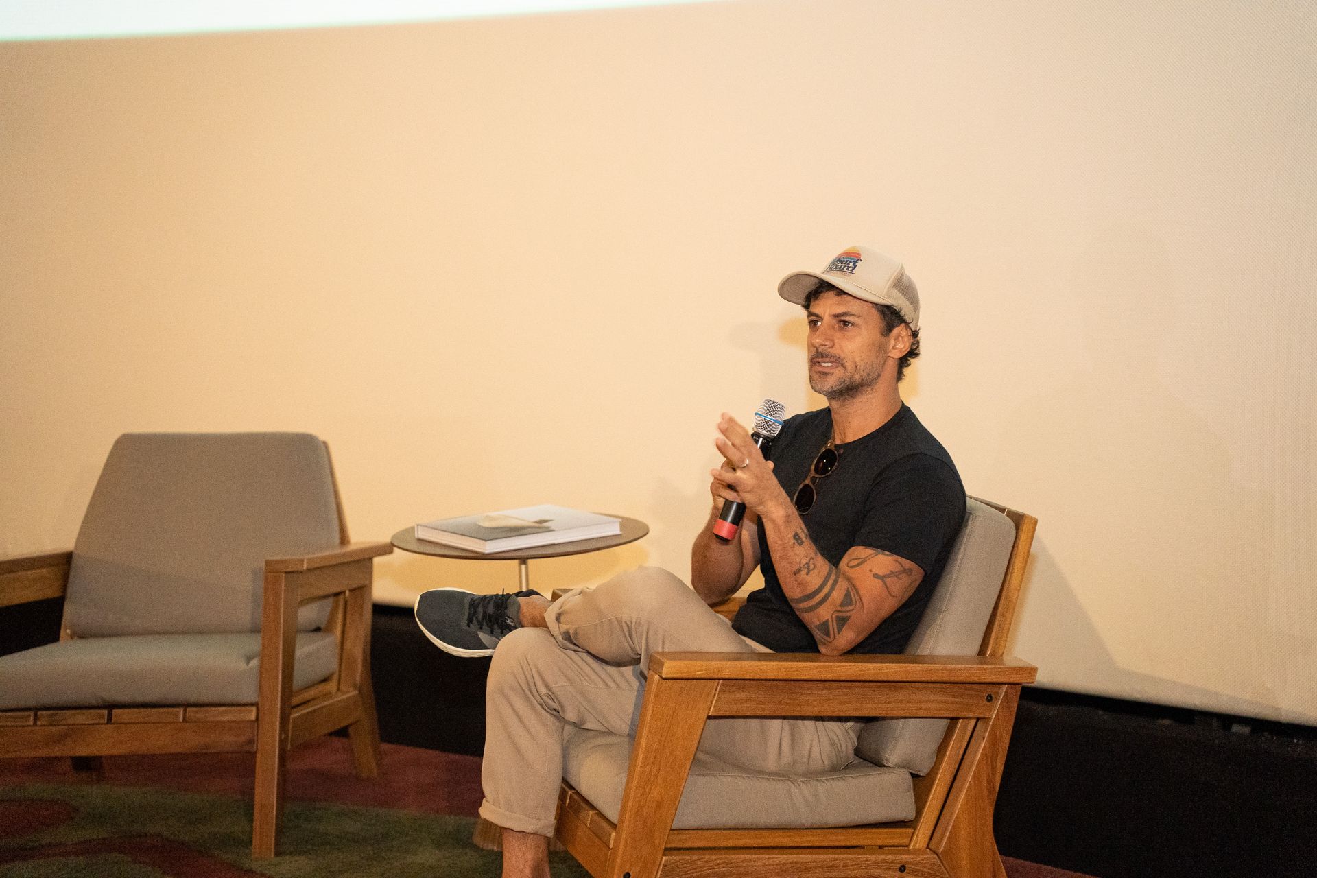 Um homem está sentado em uma cadeira segurando um microfone.