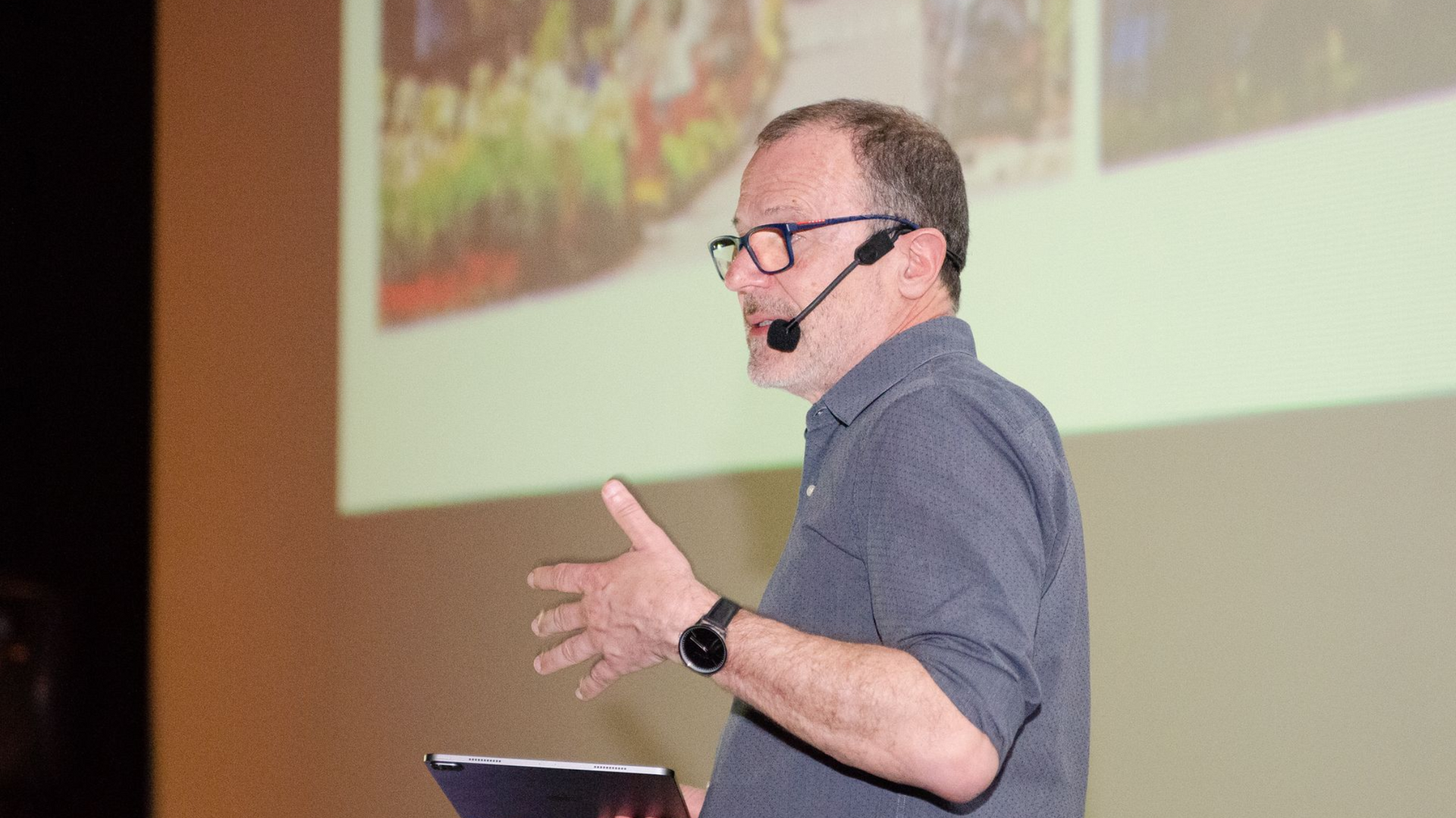 Um homem de óculos está em frente a uma placa que diz 20 anos de design com aristeu pires