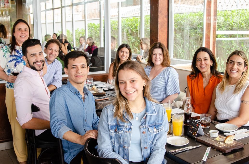 Um grupo de pessoas está sentado à mesa em um restaurante.