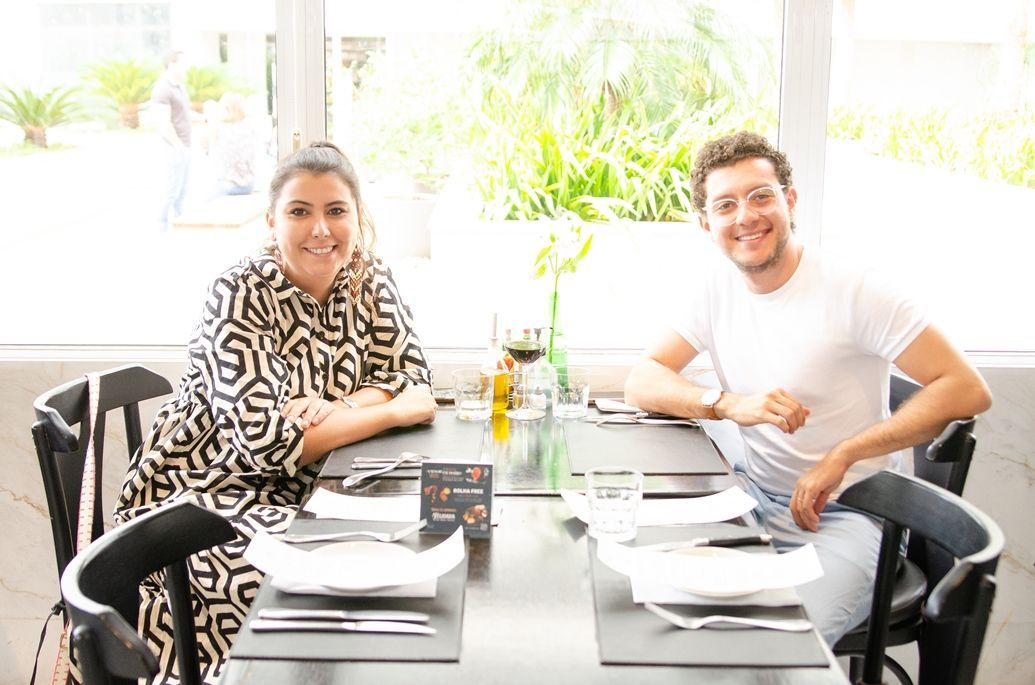 Um homem e uma mulher estão sentados à mesa em um restaurante.