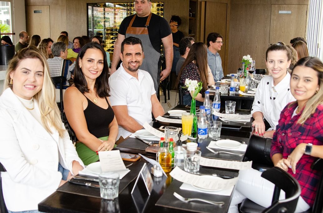 Um grupo de pessoas está sentado à mesa em um restaurante.