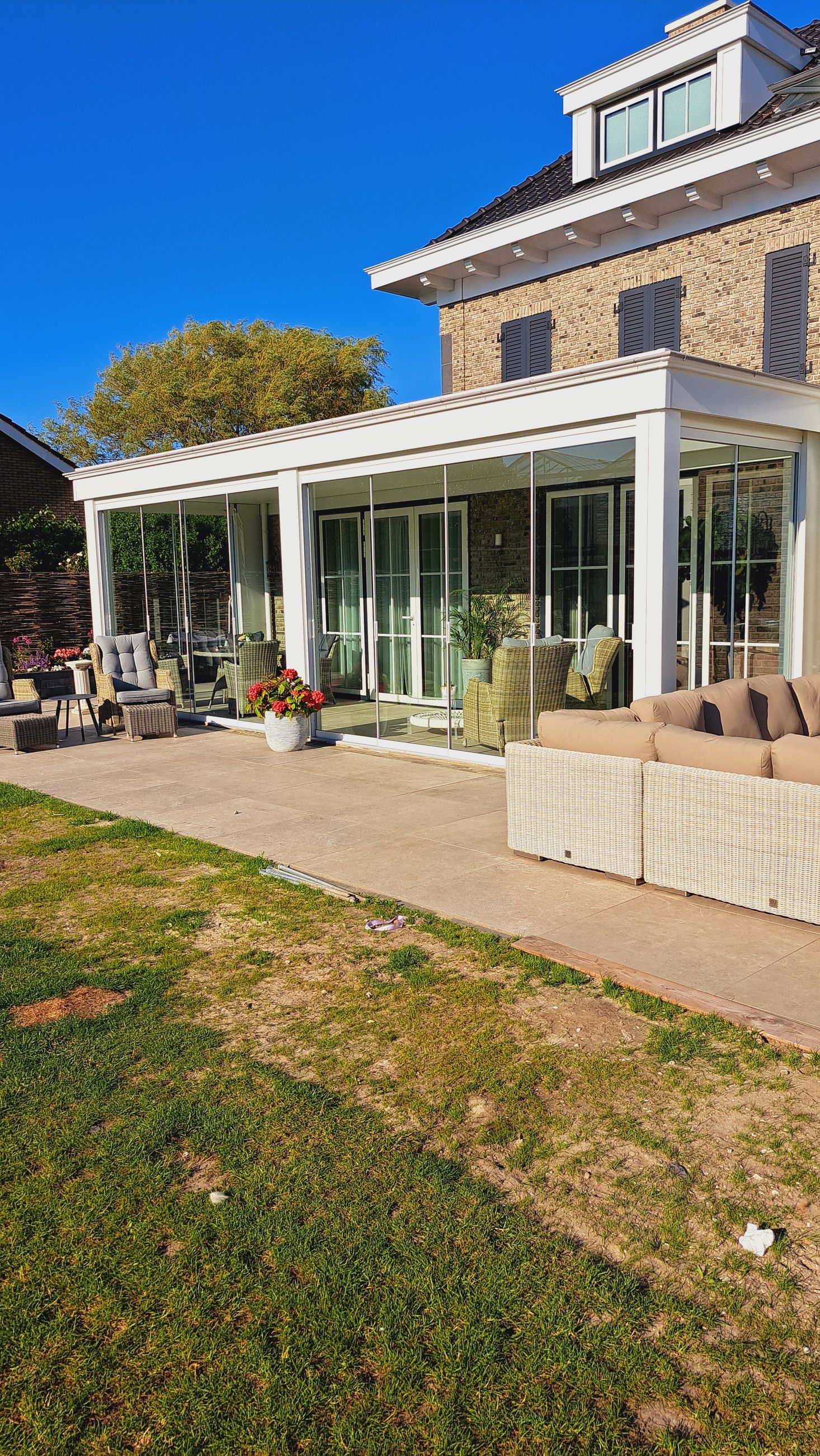 Een groot huis met een groot terras ervoor.