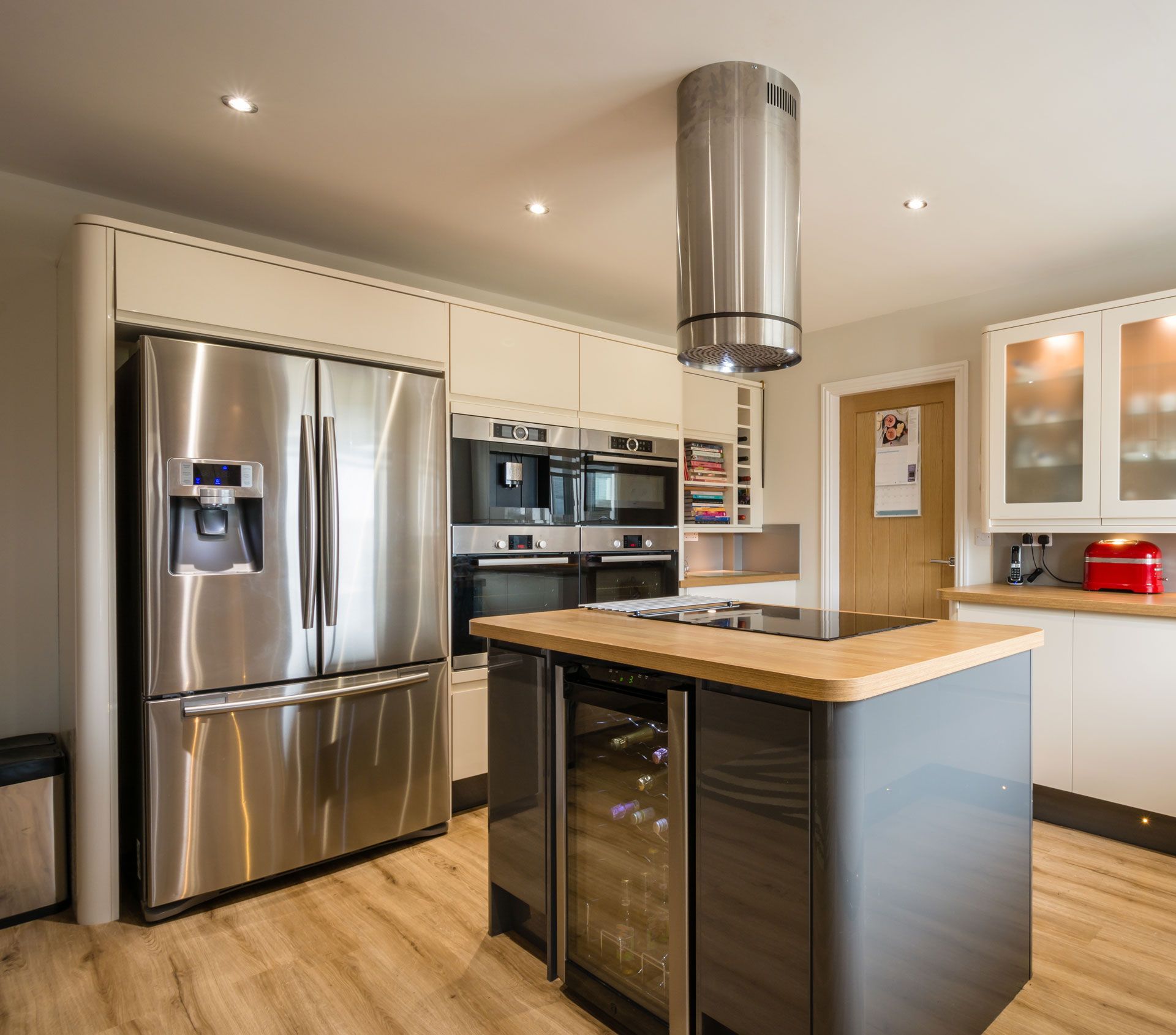 Modern kitchen with stainless steel appliances, central island, and wood flooring.