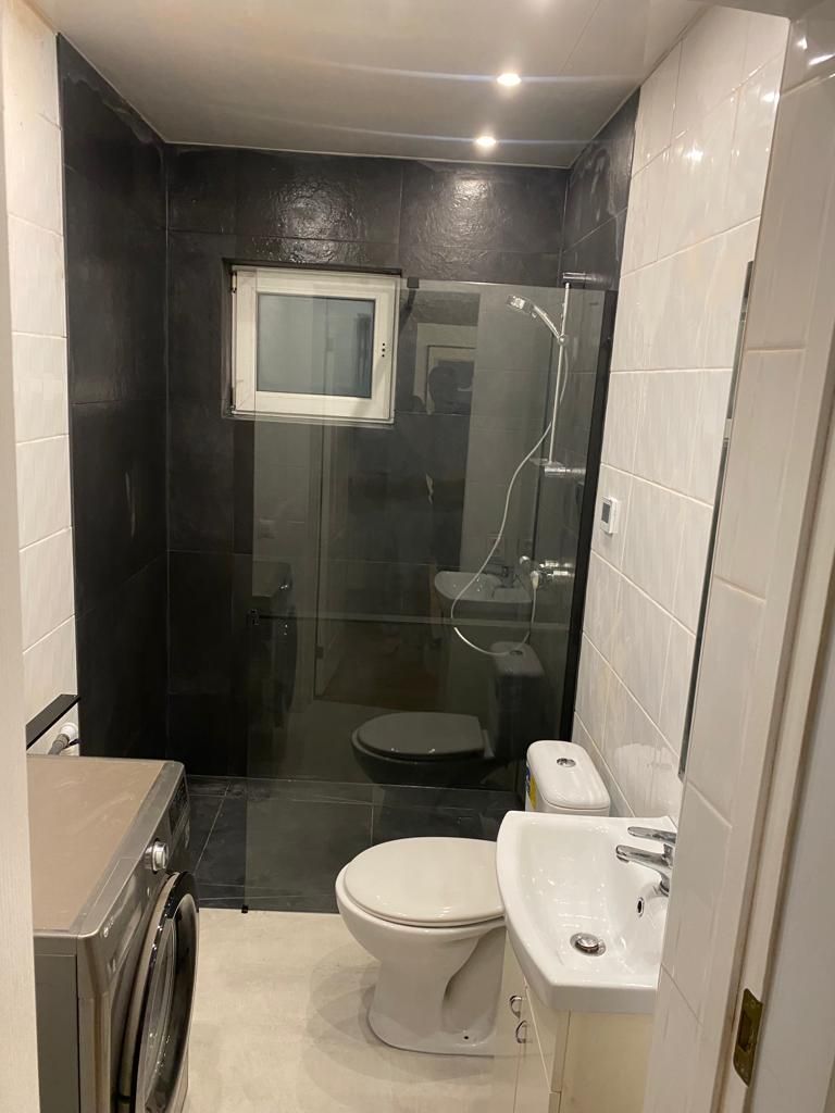 A bathroom with a toilet , sink , and shower.