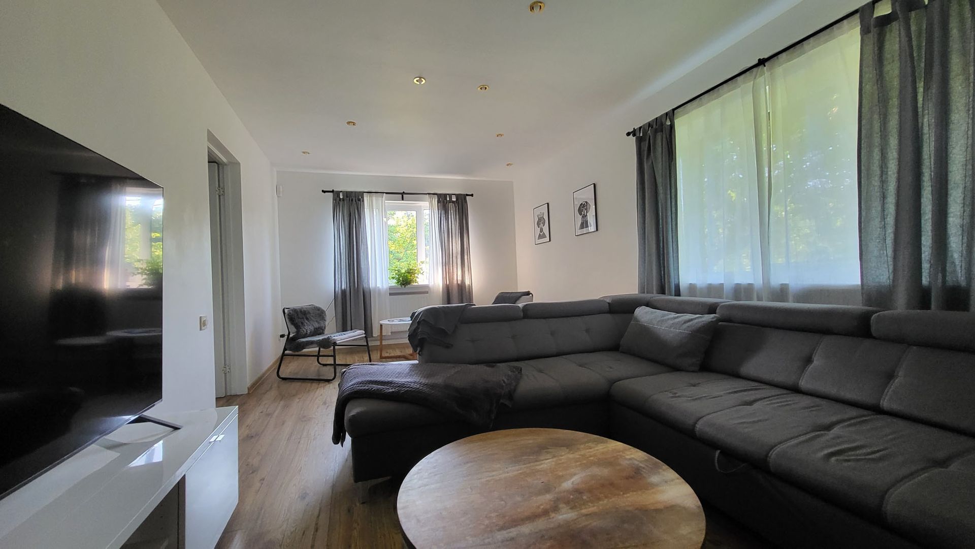 A living room with a large sectional couch and a flat screen tv.
