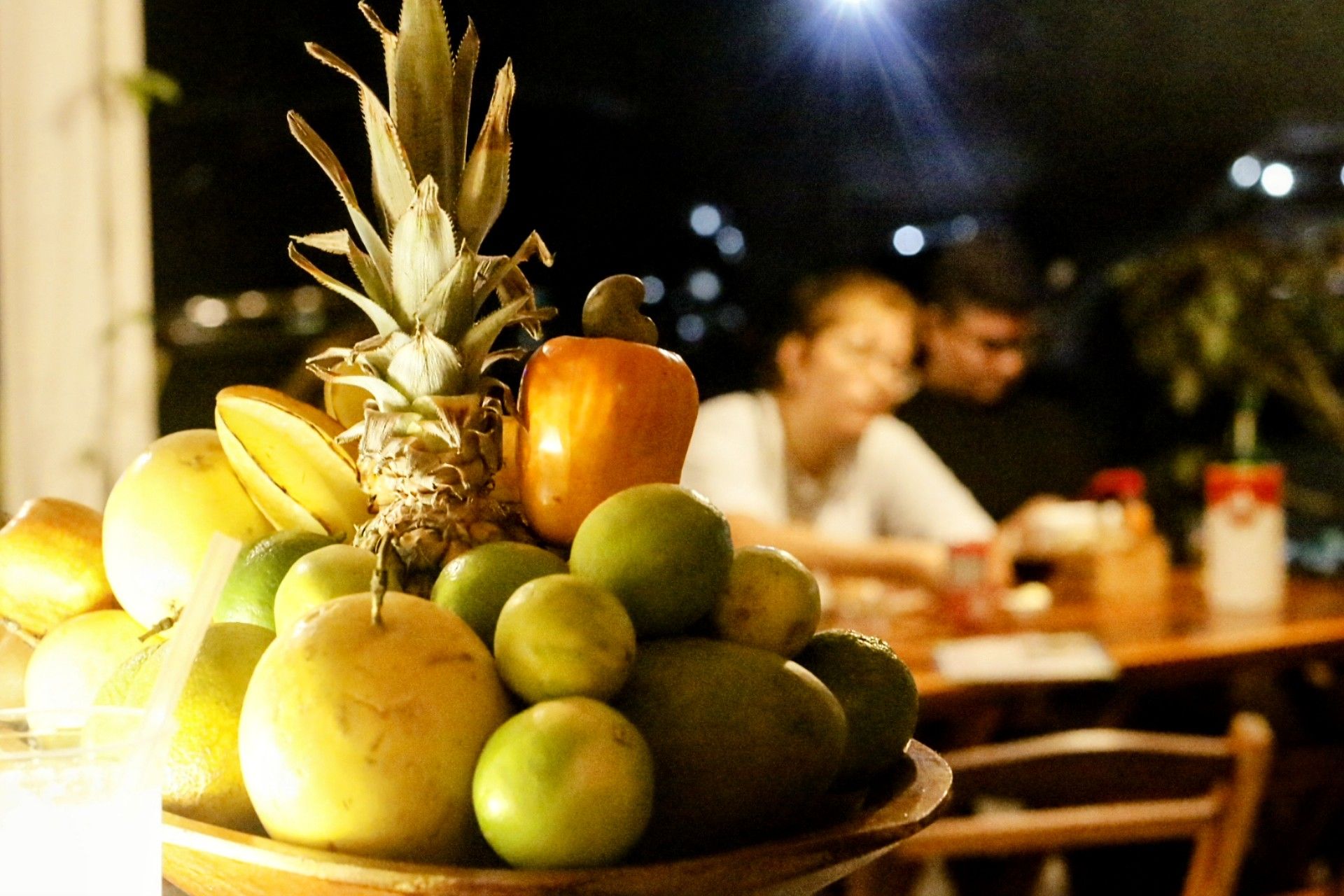 Uma tigela de frutas com um abacaxi em cima