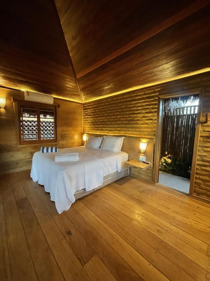 Um quarto com cama grande e piso de madeira.