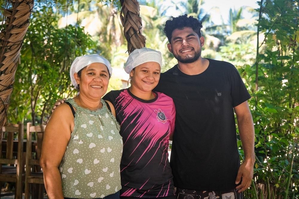 Um homem e duas mulheres posam juntos para uma foto.