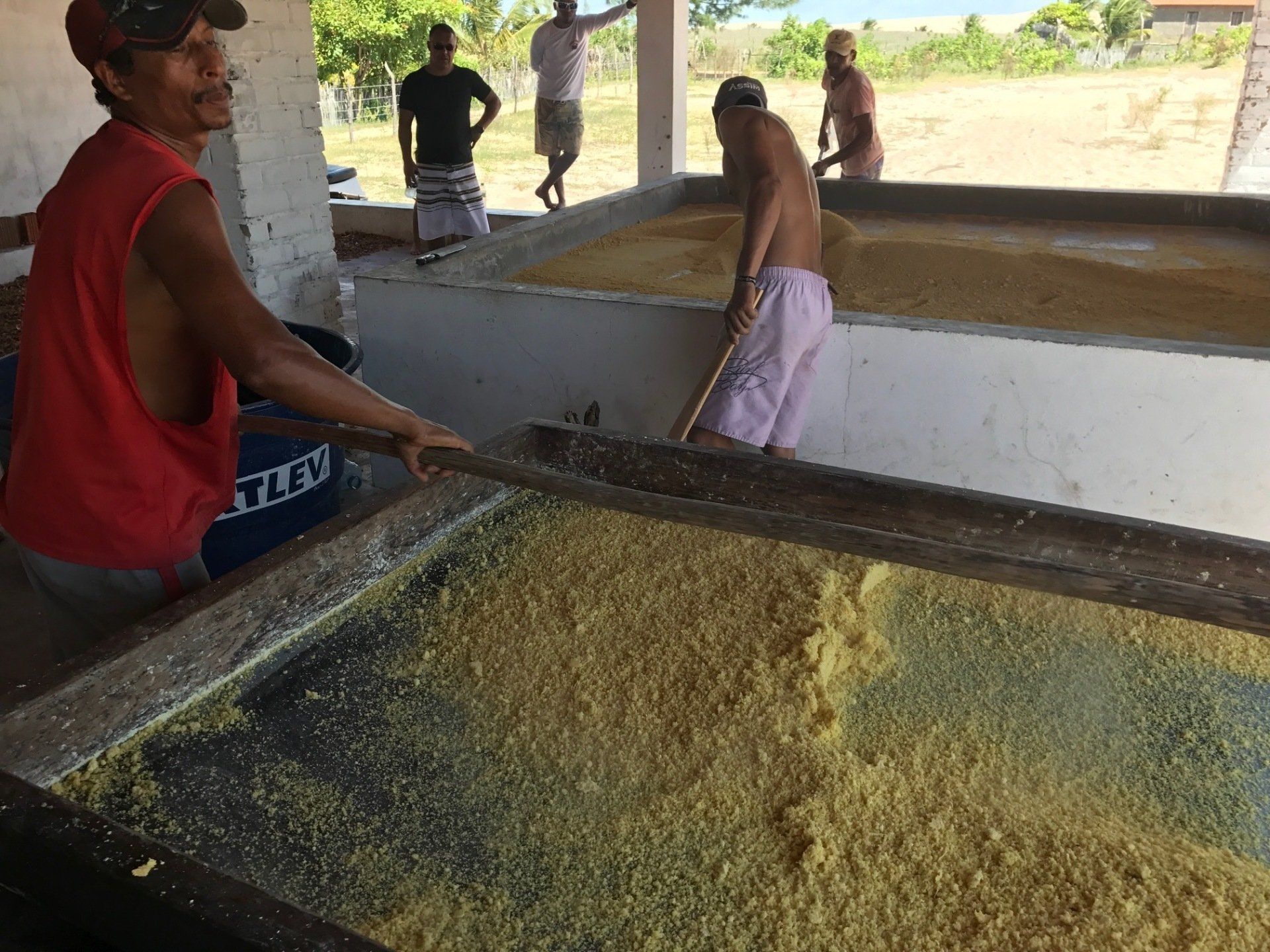 Um grupo de homens está trabalhando em uma grande pilha de comida.