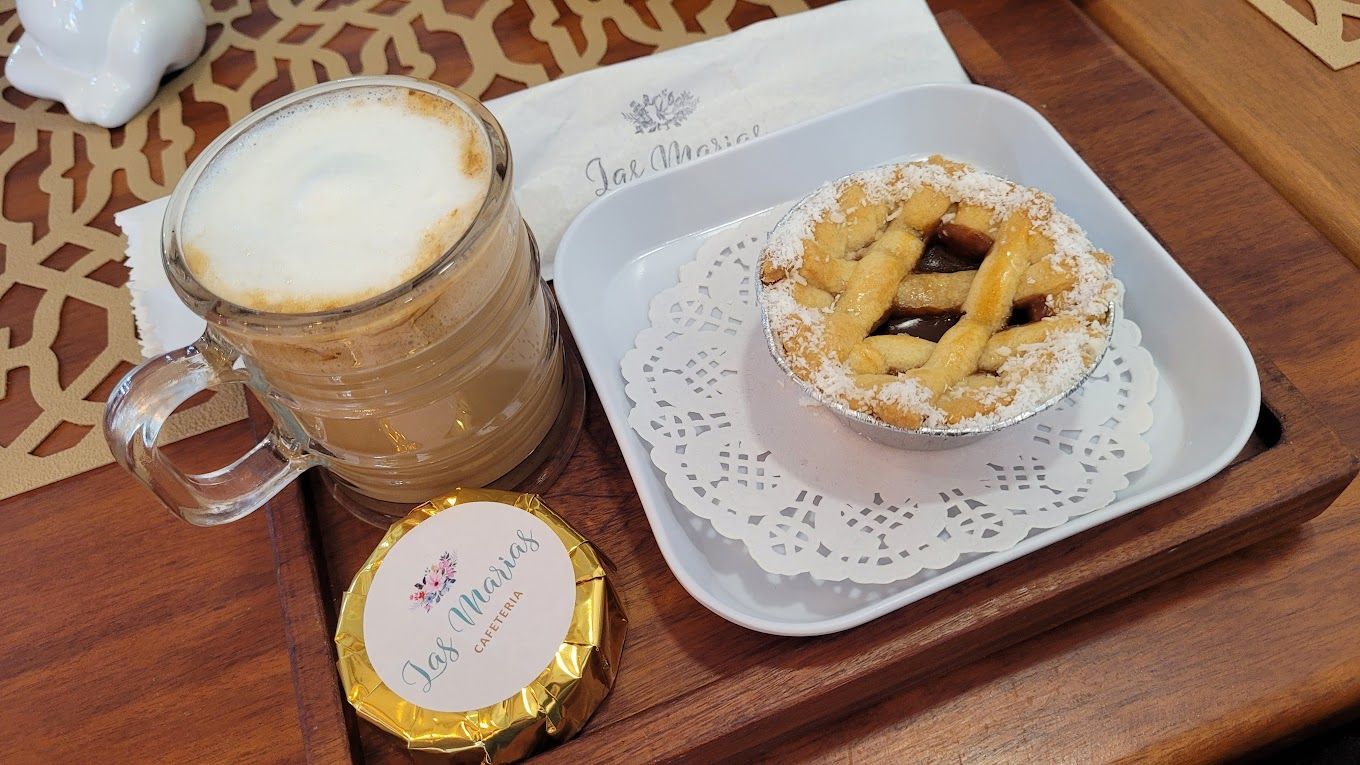 Uma xícara de café e uma torta em uma bandeja sobre a mesa.