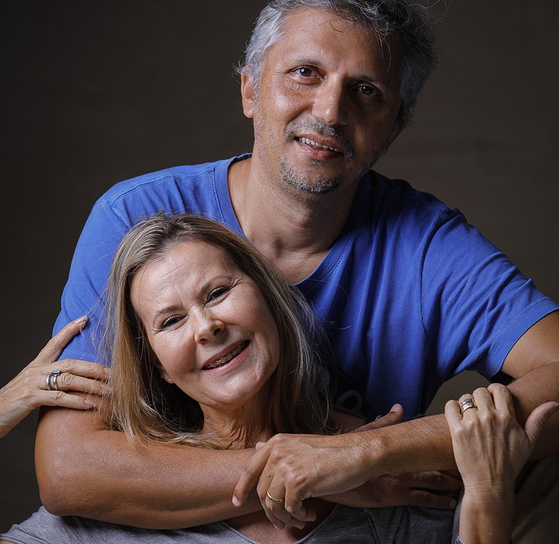 Um homem de camisa azul está abraçando uma mulher de camisa cinza