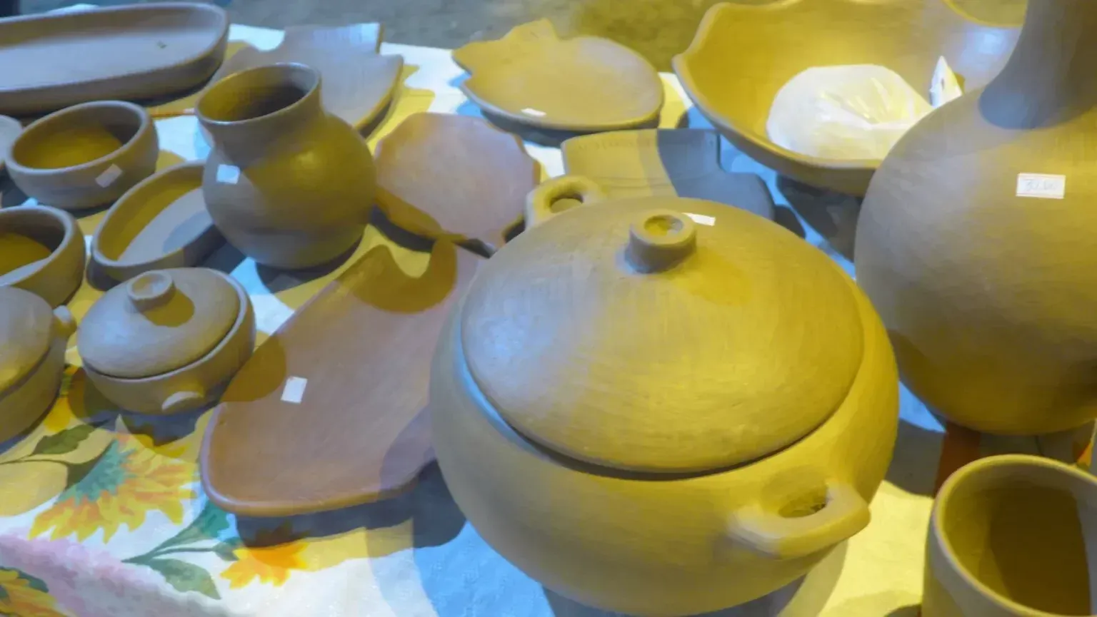 Uma mesa coberta com uma variedade de potes e tigelas de barro.