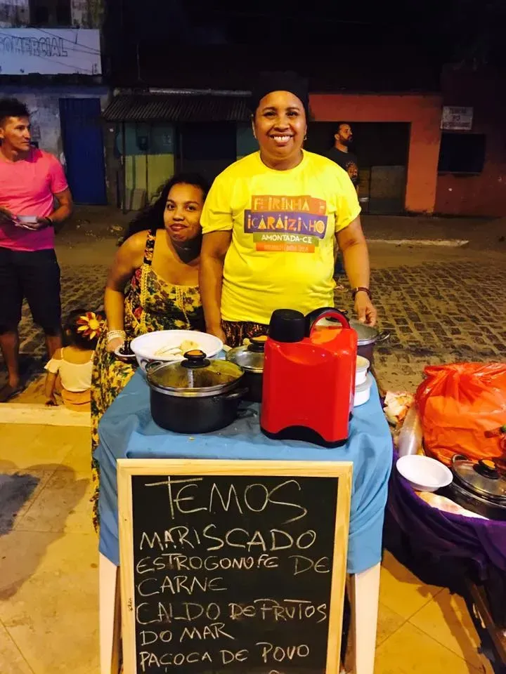 Duas mulheres estão atrás de uma mesa com uma placa que diz temos