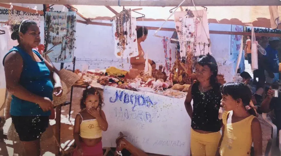 Um grupo de pessoas em volta de uma mesa com uma placa que diz medida