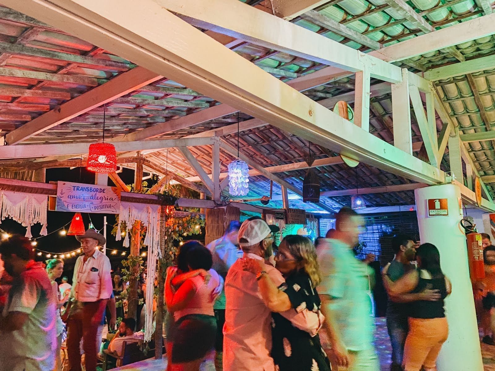 Um grupo de pessoas está dançando em uma boate à noite.