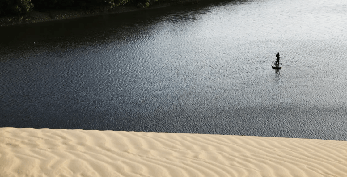 Uma pessoa está remando um barco em um corpo d’água.