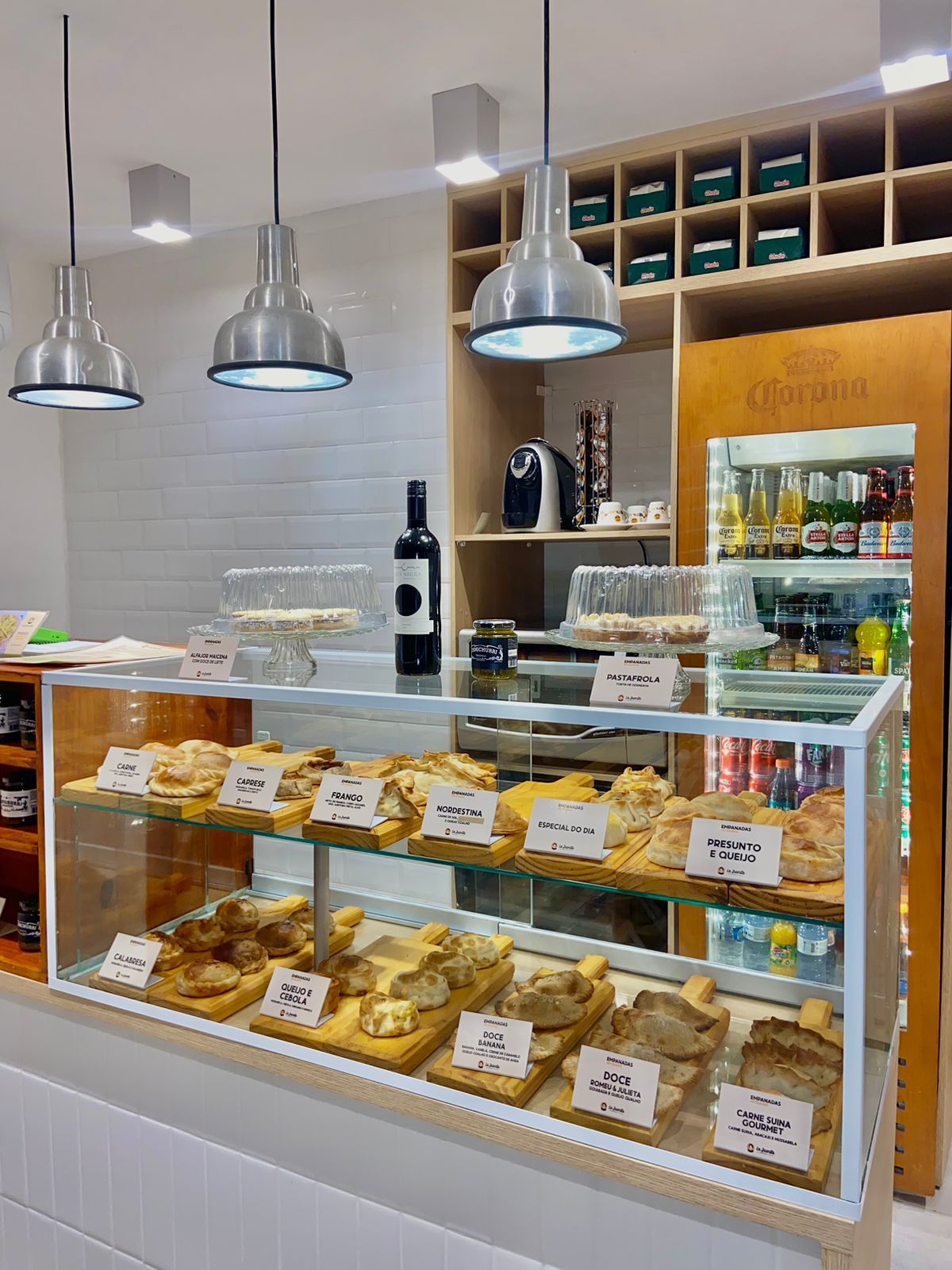 Uma padaria com vitrine de vidro repleta de pães e doces.