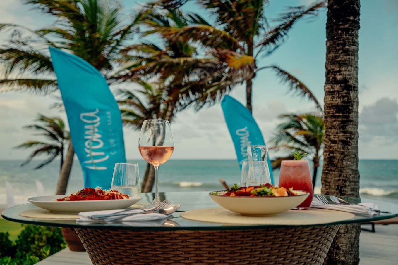 Uma mesa com uma tigela de comida e uma taça de vinho