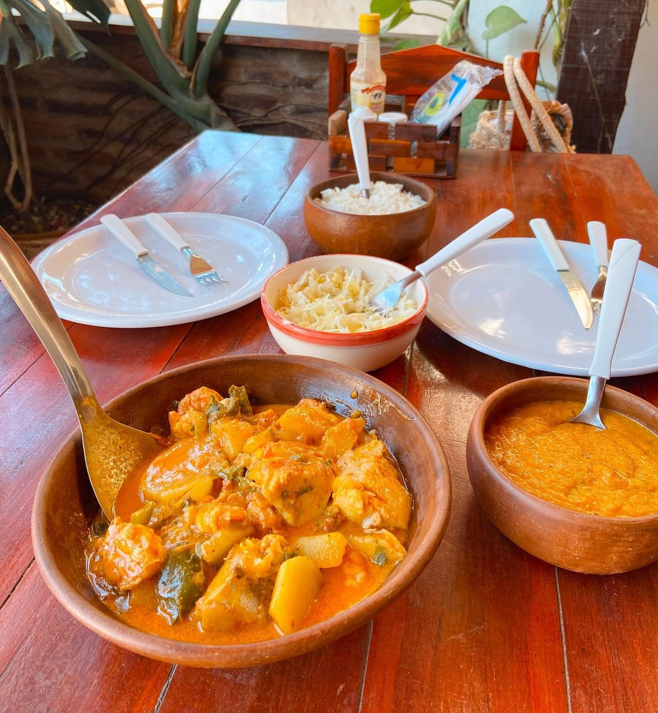 Um prato de comida com camarão e arroz em uma mesa de madeira.