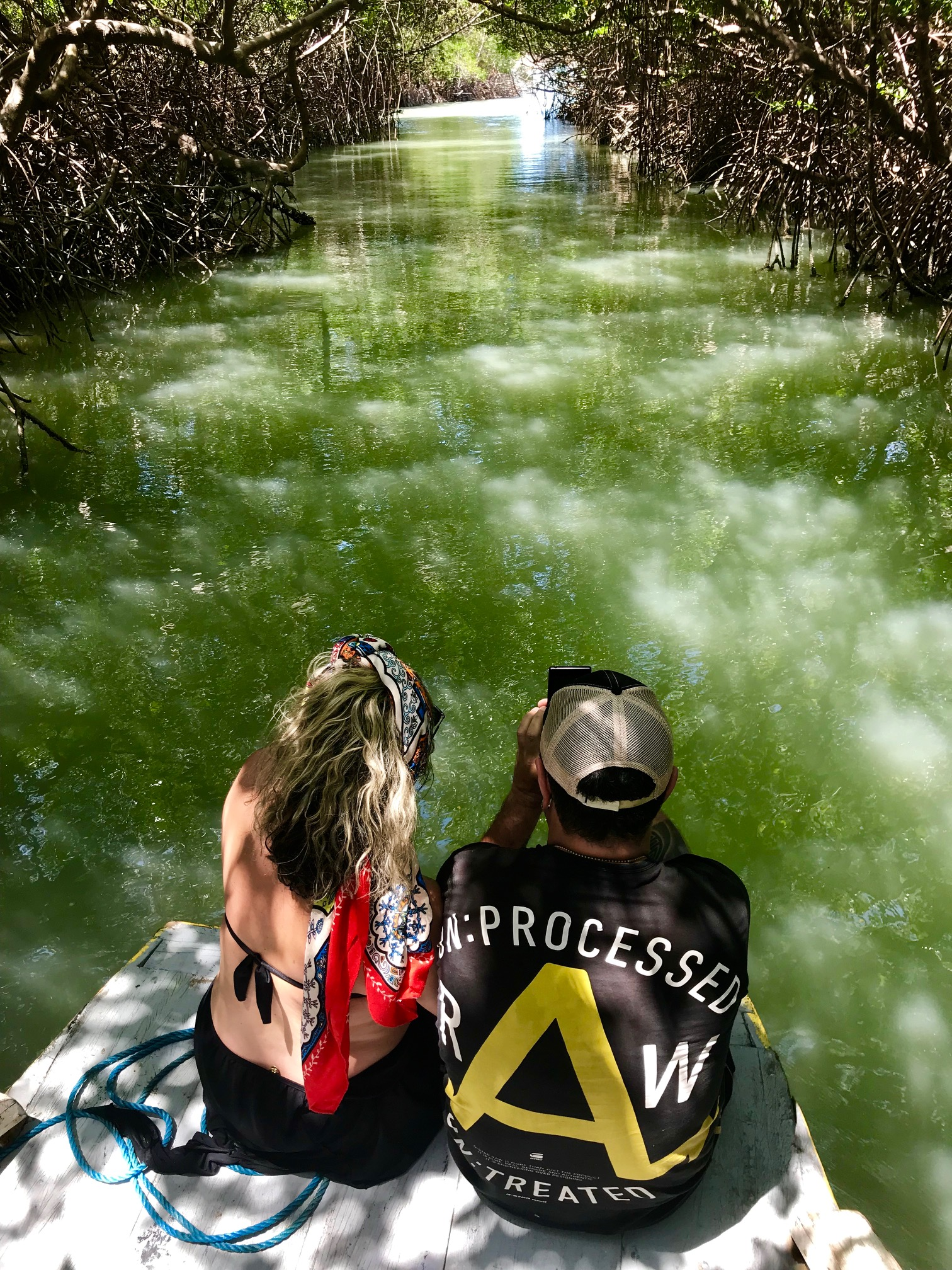 Um homem e uma mulher estão sentados em um barco olhando para um rio.