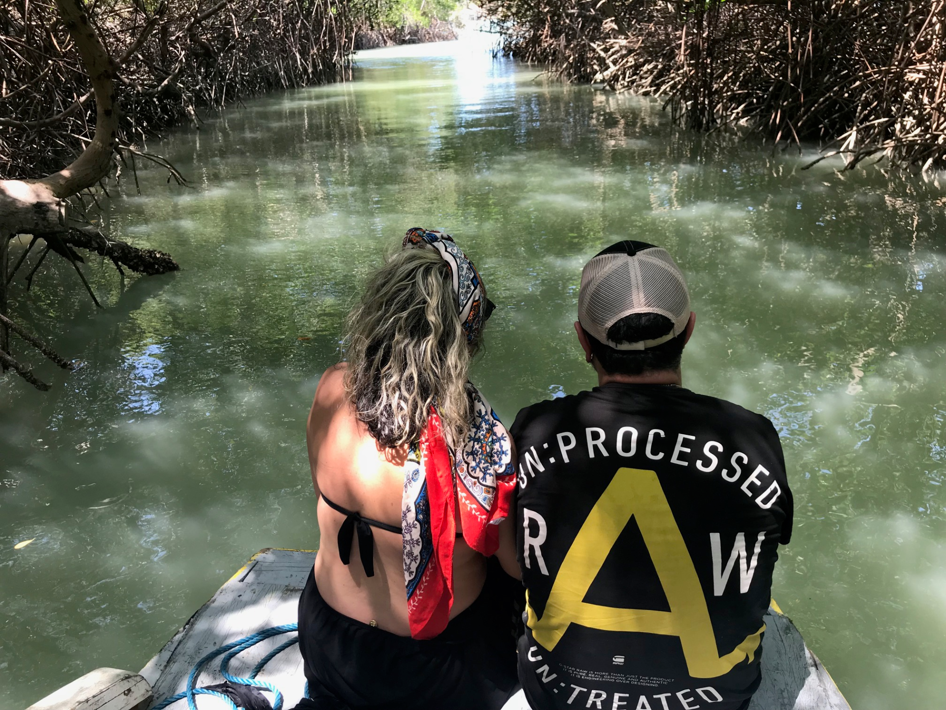 Um homem e uma mulher estão sentados em um barco olhando para um rio.