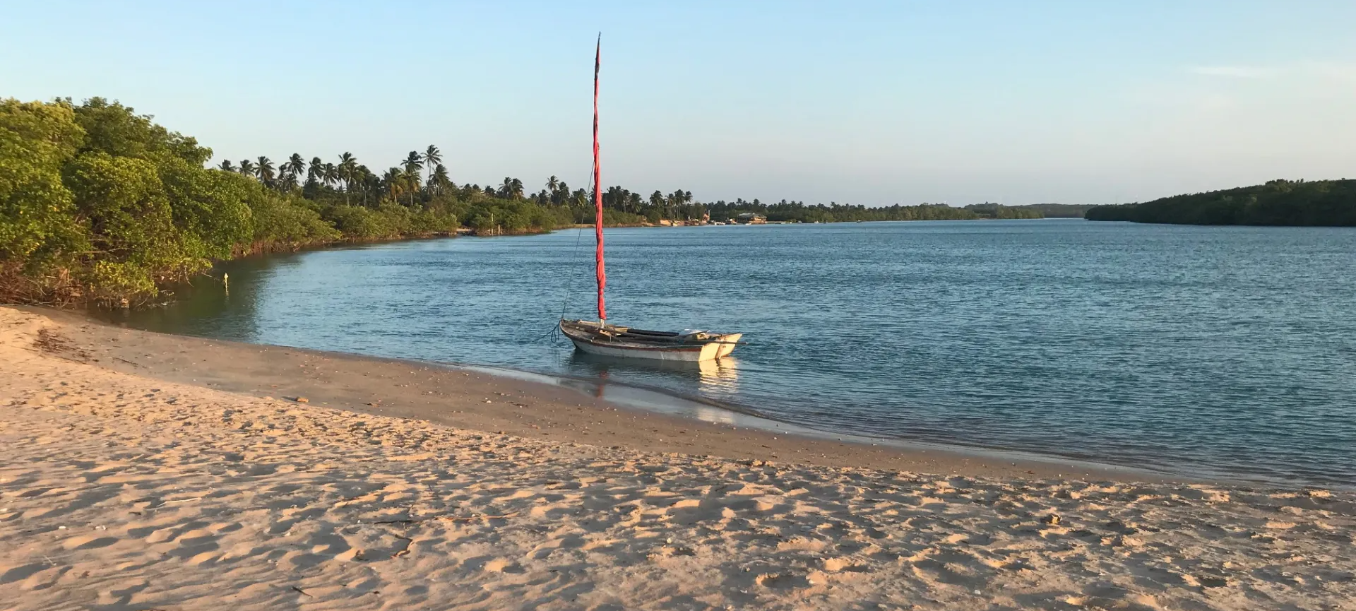 Um pequeno barco está parado na margem de um corpo de água.