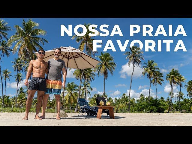 Dois homens parados em uma praia sob um guarda-sol com as palavras nossa praia favorita acima deles