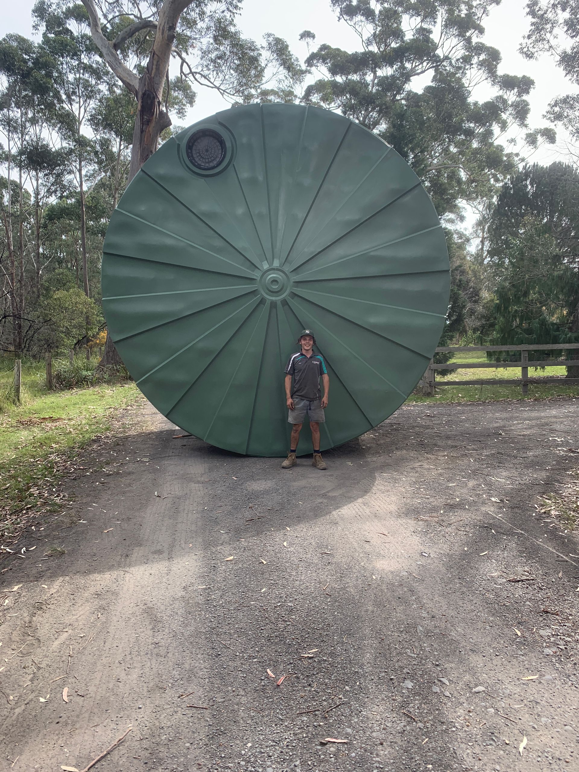 A Row Of Blue Water Tanks Are Sitting On Top Of A Wooden Platform — Bennett's Environmental In South Nowra, NSW