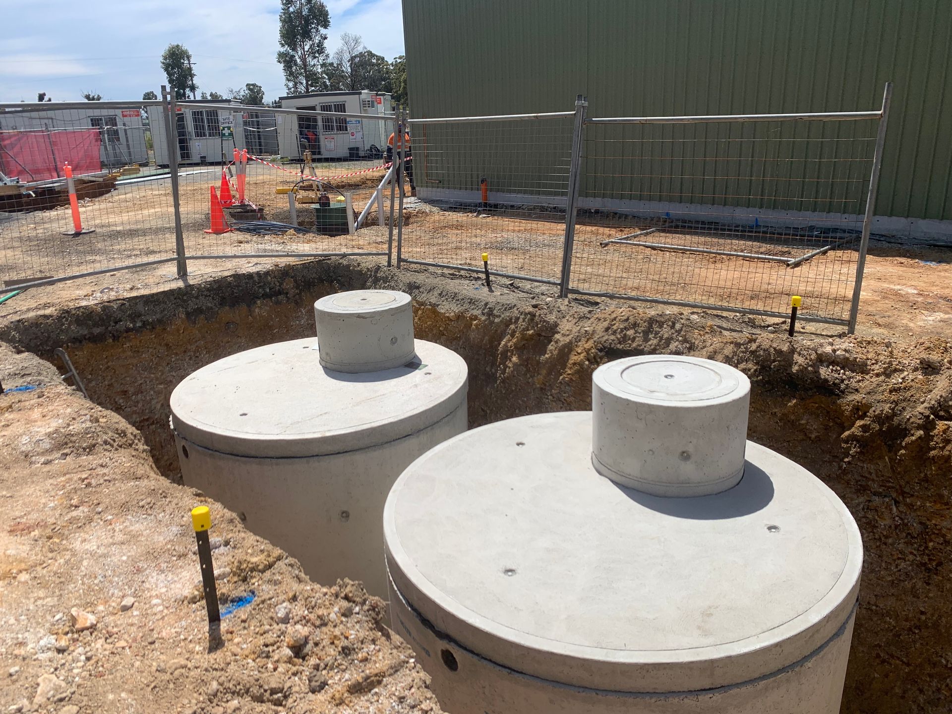 A Man Is Smiling In Front Of A Bennett 's Environmental Sign — Bennett's Environmental In South Nowra, NSW