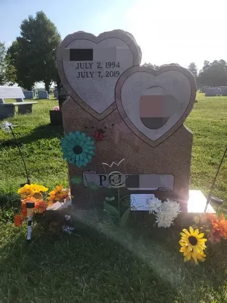 A grave in a cemetery with two hearts on it