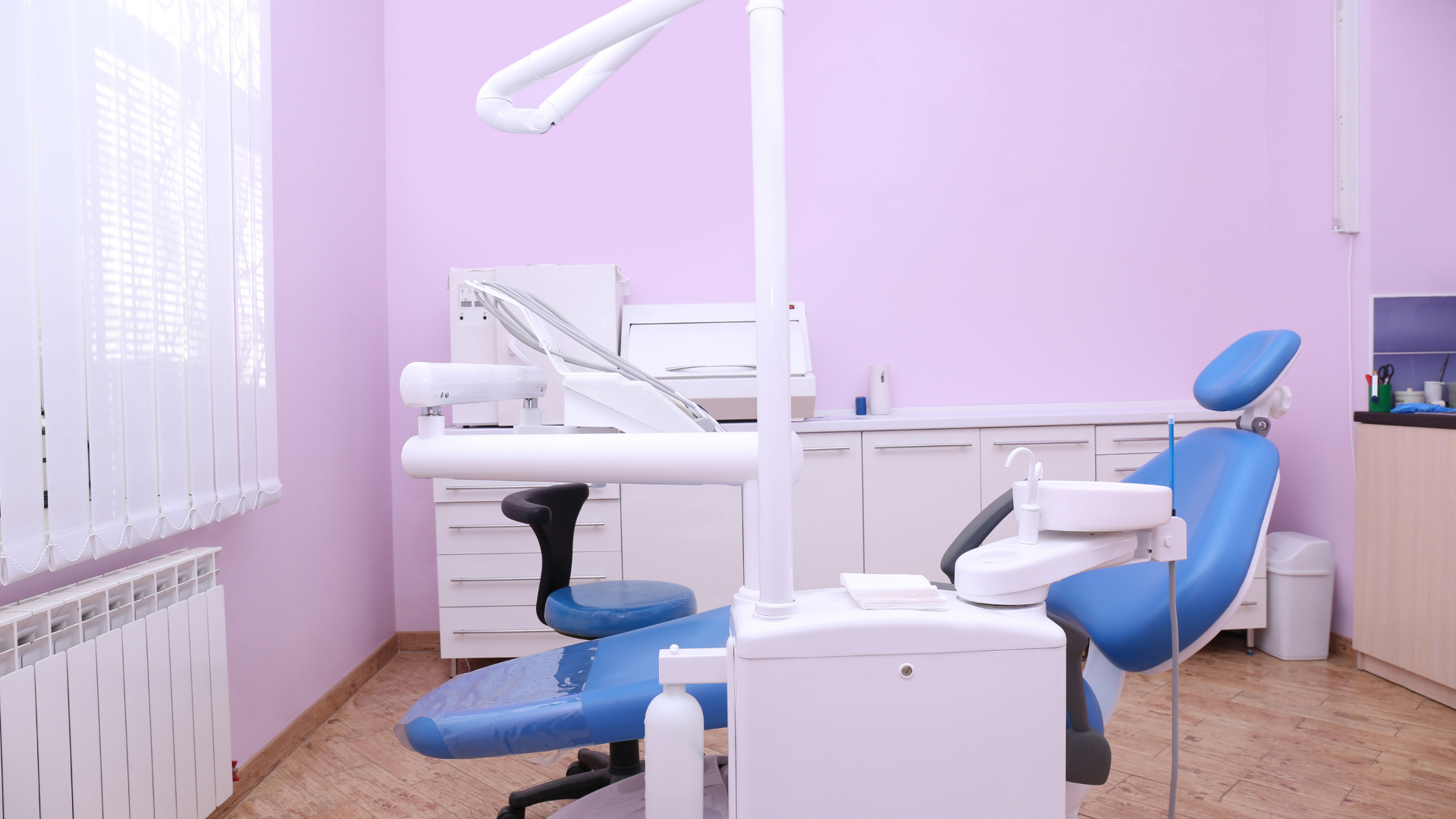 There is a blue dental chair in the dental office.