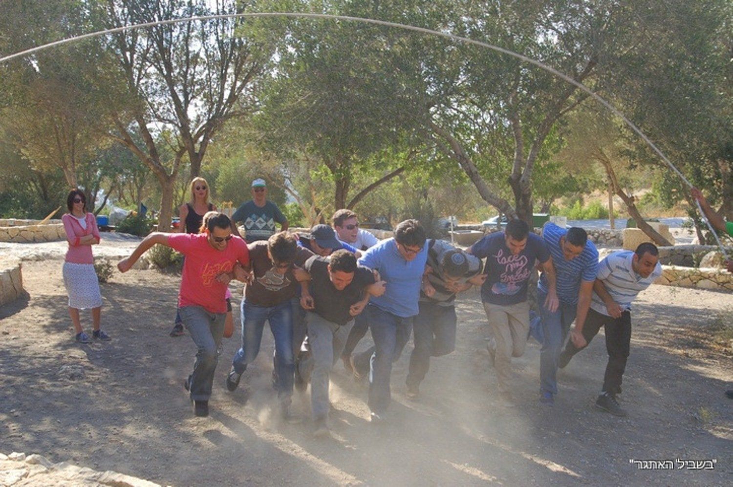קבוצה של אנשים רצים בעפר עם עצים ברקע