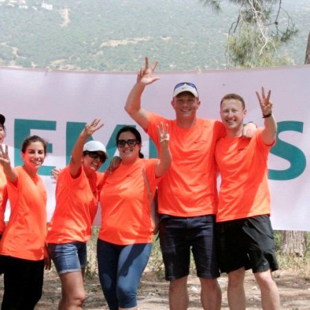 קבוצת אנשים עומדת מול שלט שאומר אוונס