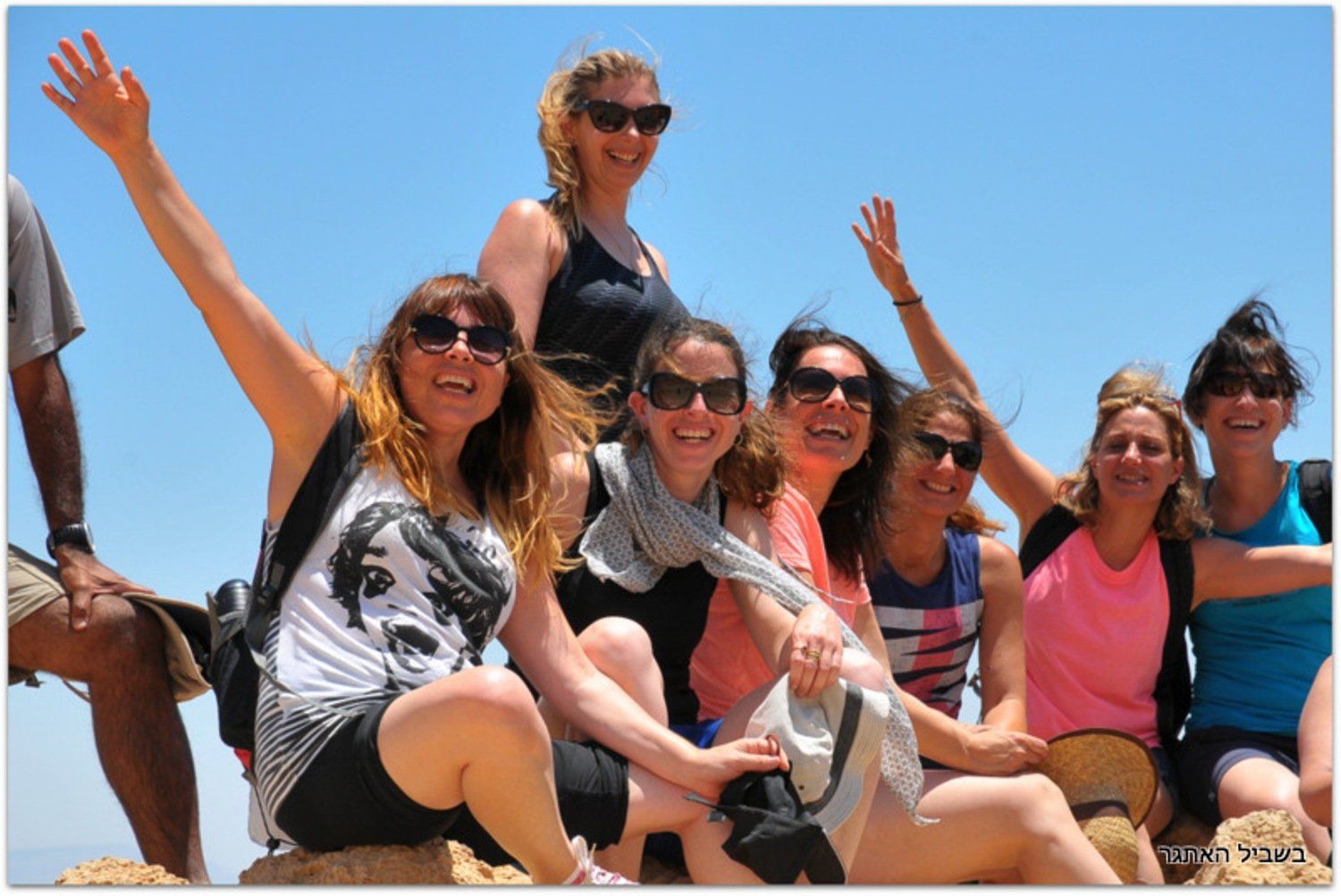 קבוצת נשים מצטלמת עם זרועותיהן באוויר