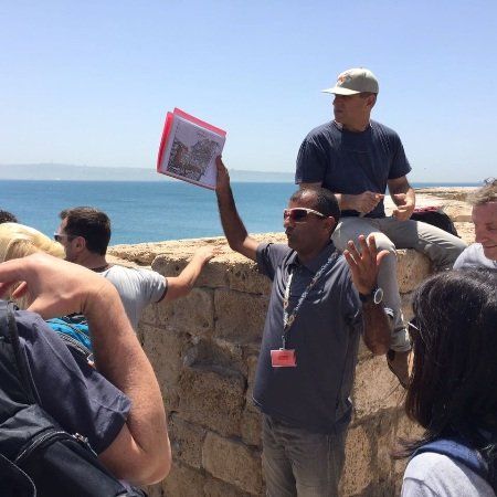 קבוצת אנשים עומדת על חומת אבן ליד האוקיינוס