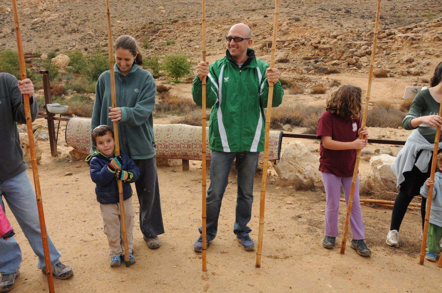 קבוצת אנשים מחזיקה מוטות עץ בעפר