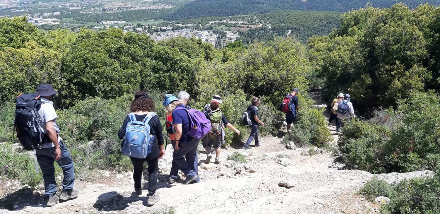 קבוצה של אנשים עם תרמילים הולכים בשביל עפר.