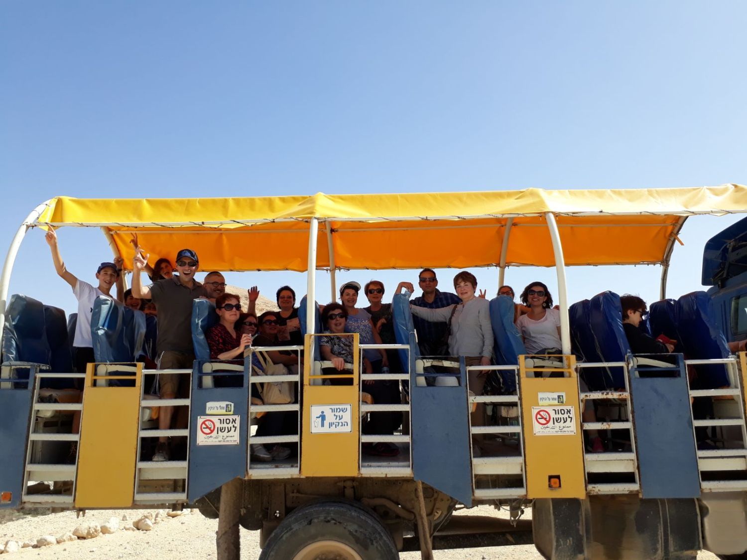 קבוצה של אנשים נוסעת על גב משאית.