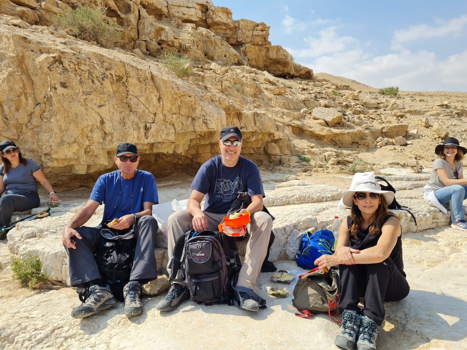 קבוצת אנשים יושבת על סלע במדבר.