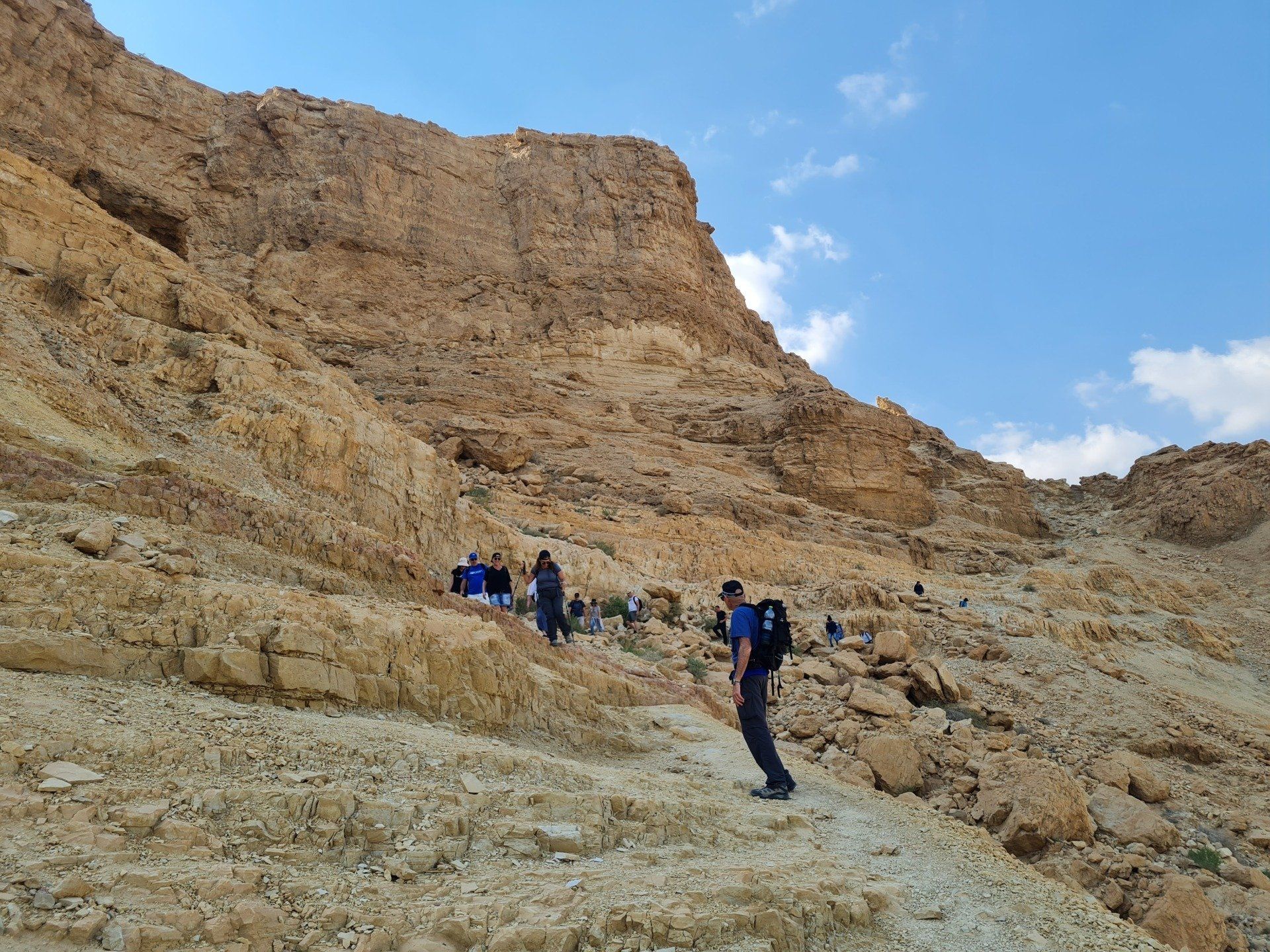 קבוצת אנשים צועדת בשביל עפר במדבר.