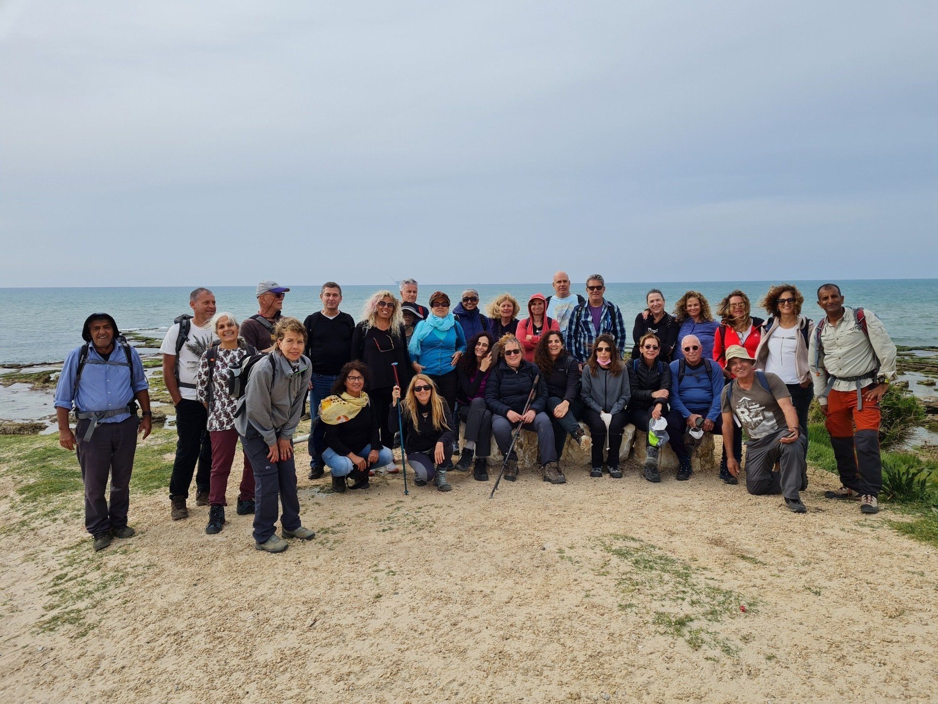 קבוצה של אנשים מצטלמים על החוף.