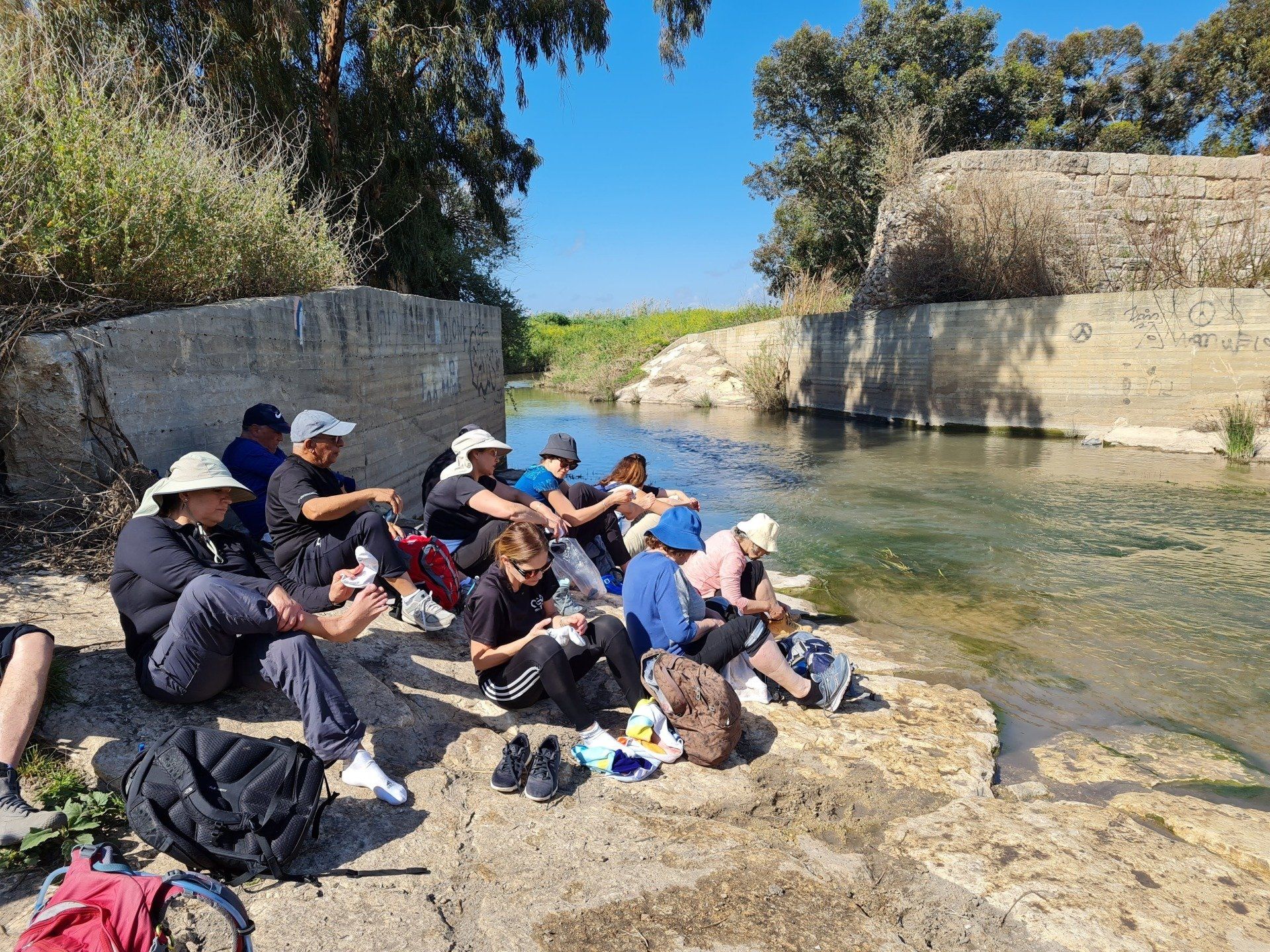 קבוצת אנשים יושבת על סלע ליד נהר.