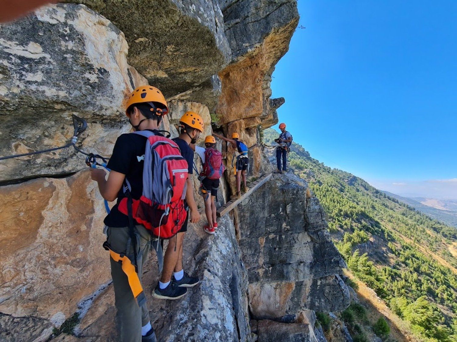 קבוצת אנשים עומדת על קצה צוק.