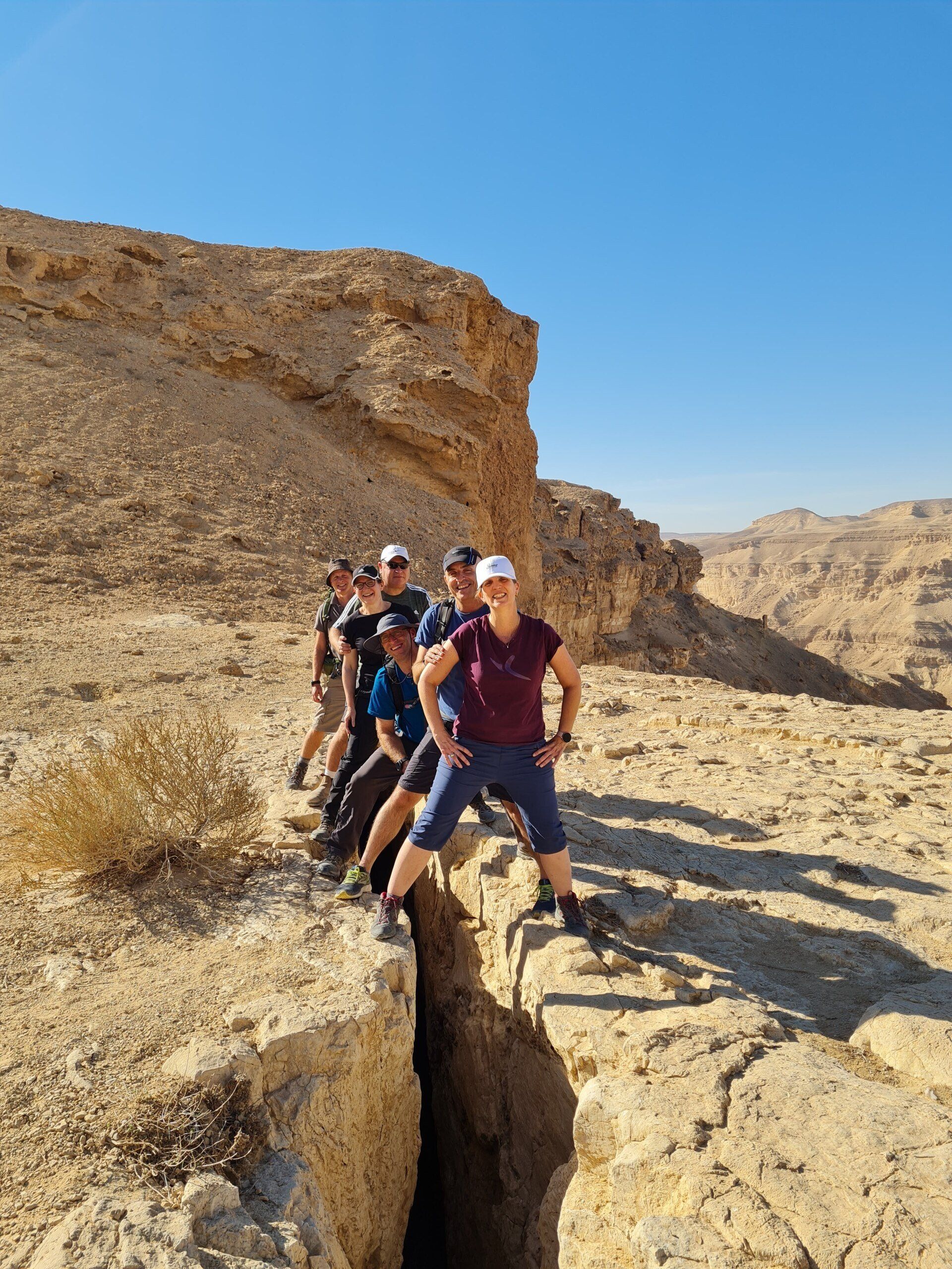 קבוצת אנשים עומדת על ראש צוק סלעי.