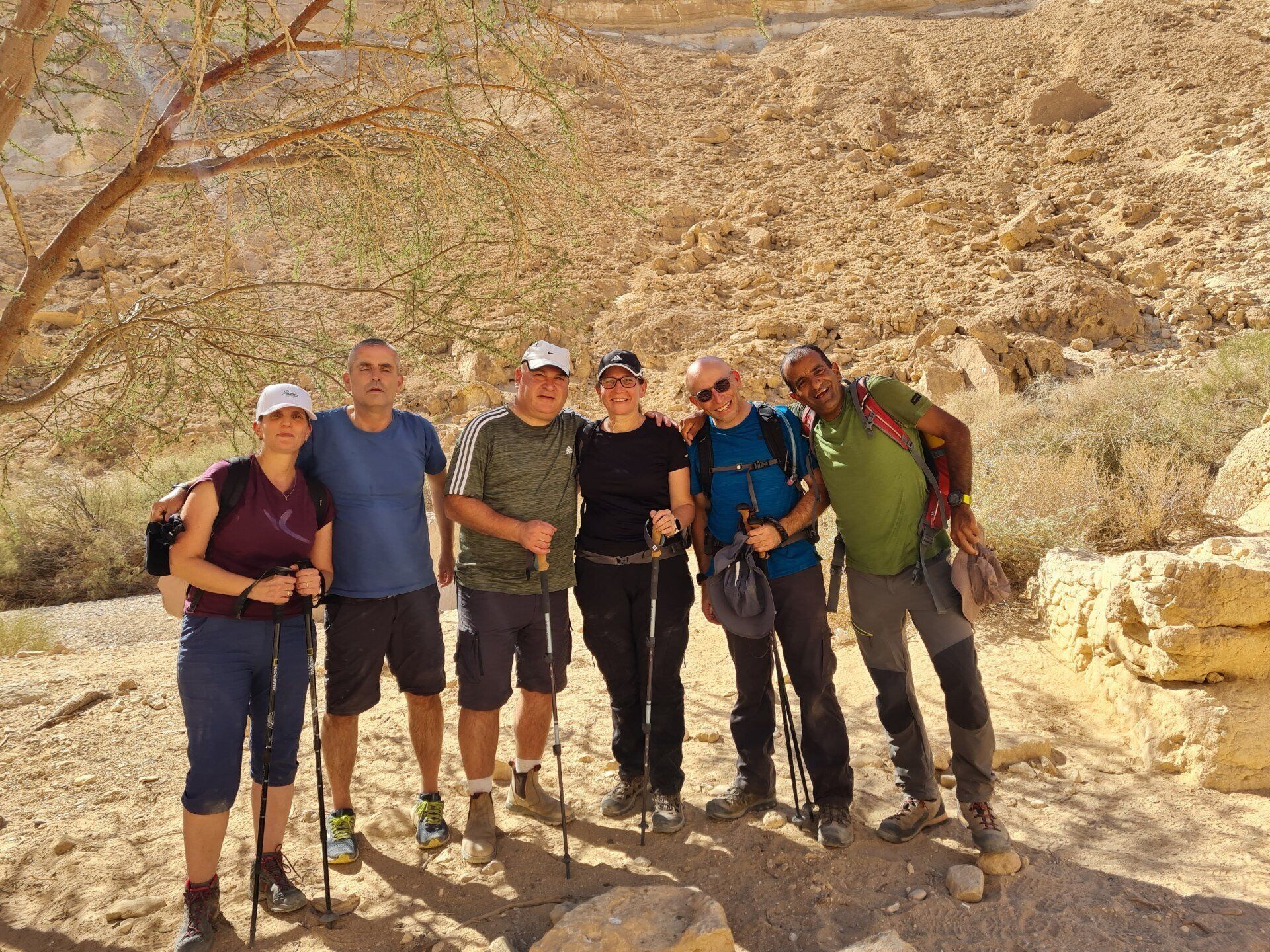 קבוצה של אנשים מצטלמים במדבר.