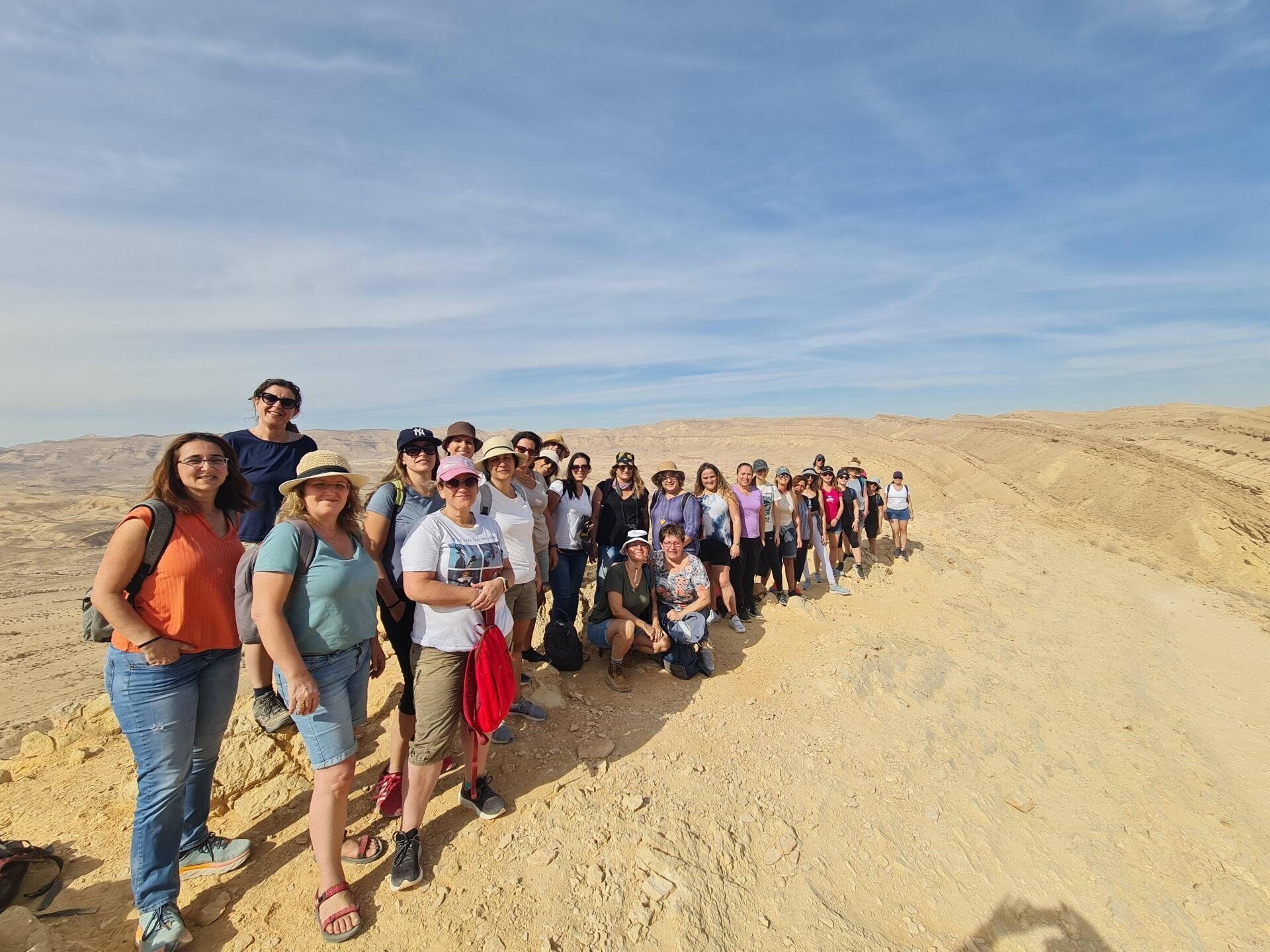 קבוצה של אנשים מצטלמים במדבר.